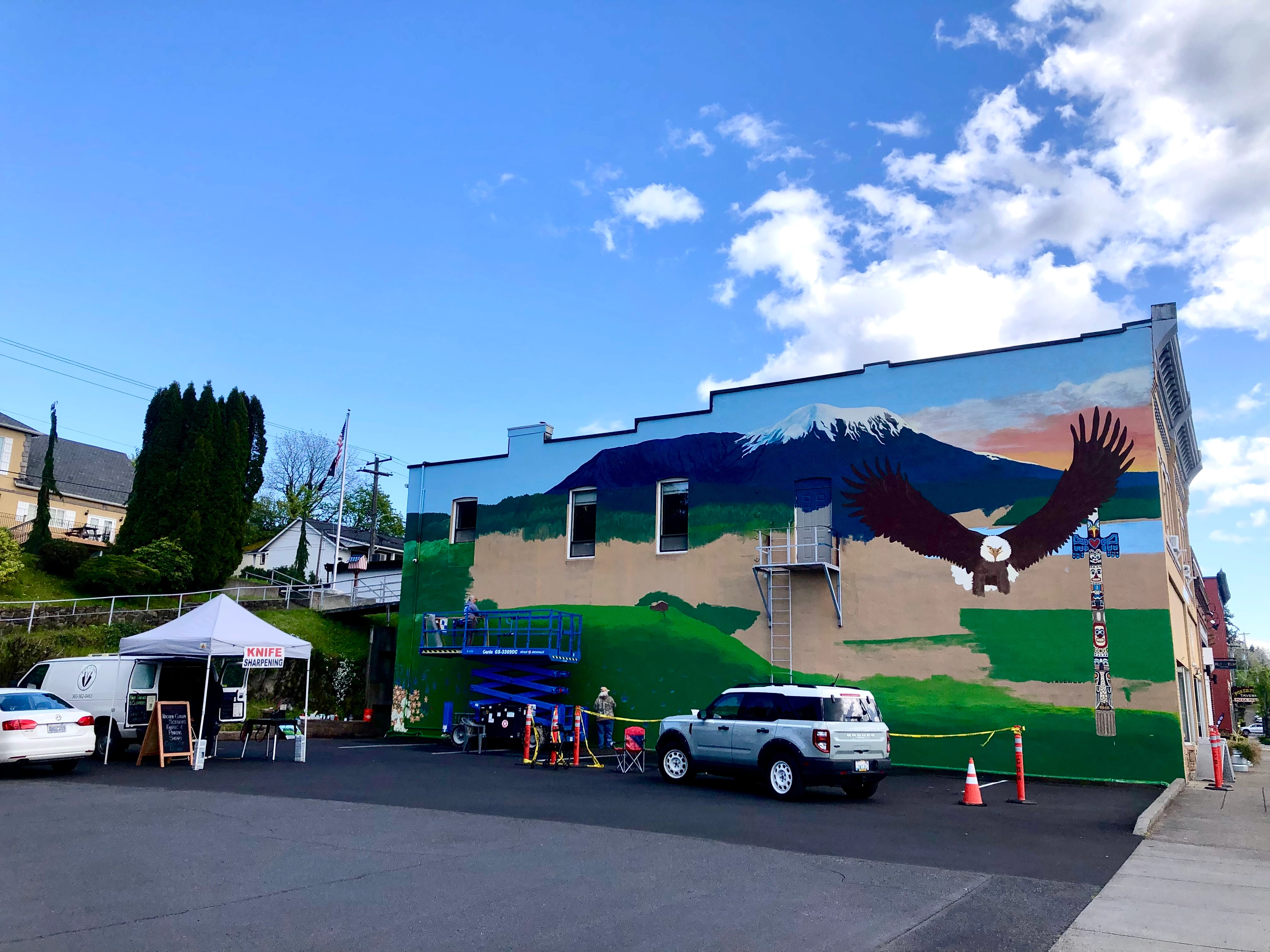 The downtown Kalama mural takes shape on First Street, April 2026, as daily life continues around it